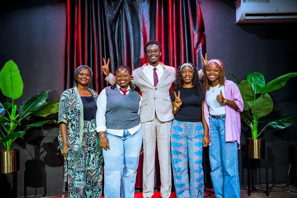 Precious Alo with four members of The Scepter community in front of a burgundy curtain