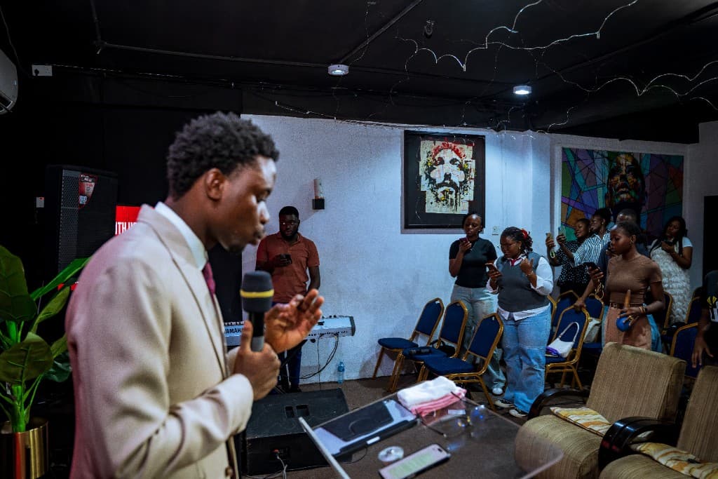 Precious Alo ministering to a room of young believers standing in worship